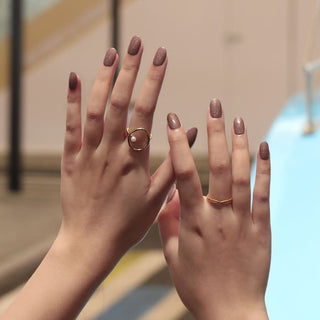 Bluesky Nude Pink Happy Go Lucky Gel Polish with fine glitter on models hands. Model wears gold rings.